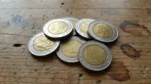 Monete italiane da 500 lire bimetalliche su un tavolo in legno