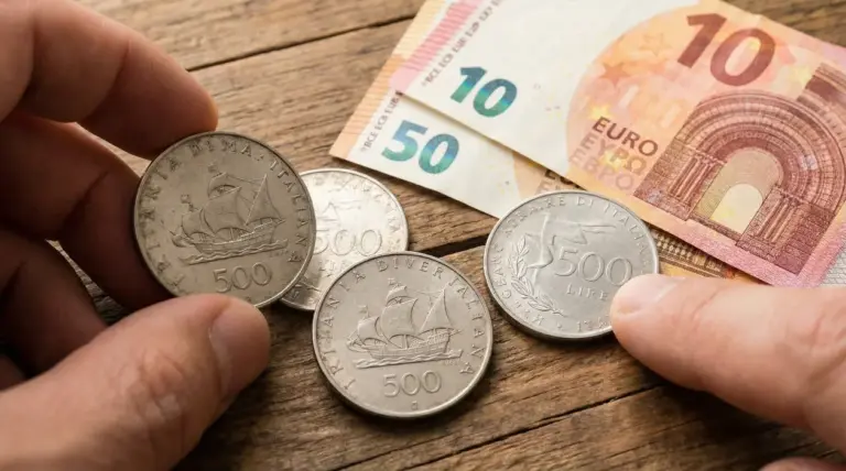 Monete da 500 lire d'argento accanto a banconote in euro su tavolo di legno